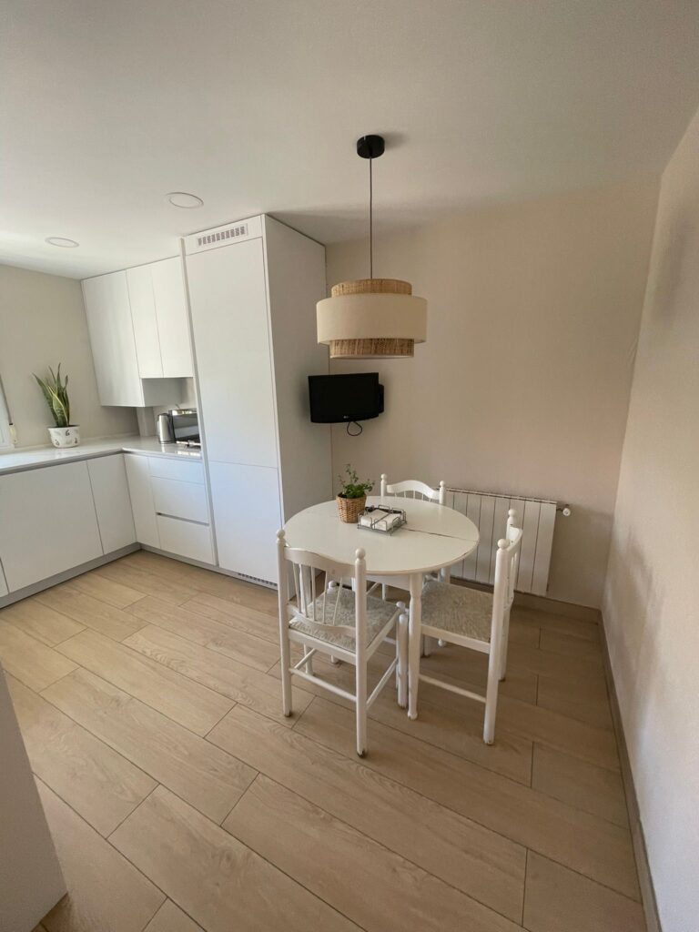Cocina reformada con office, muebles blancos y mesa redonda
