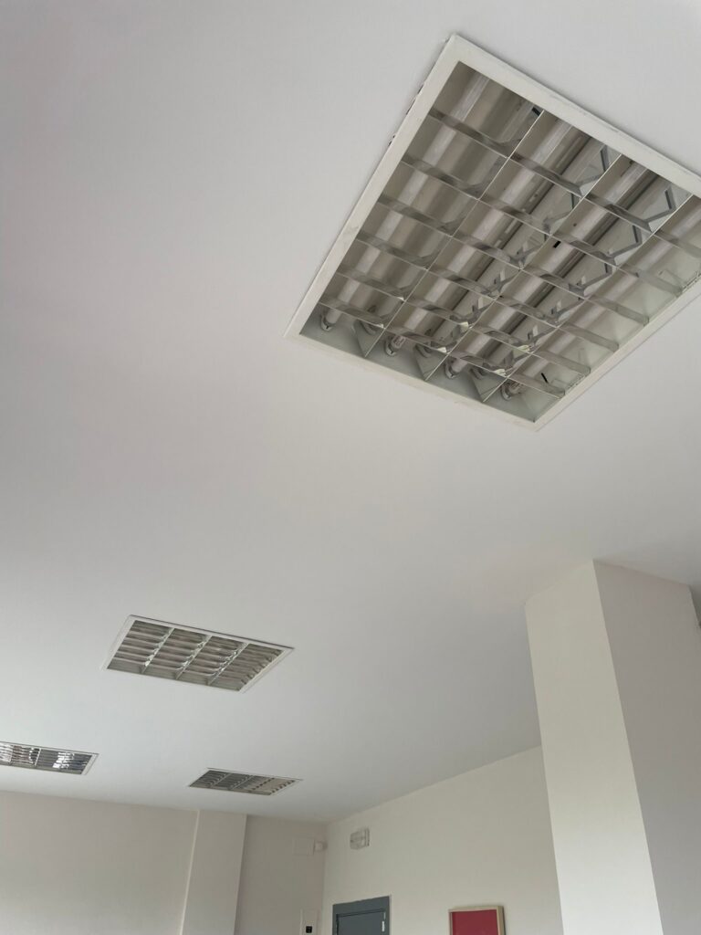 Techo de oficina reparado y pintado con rejillas de climatización