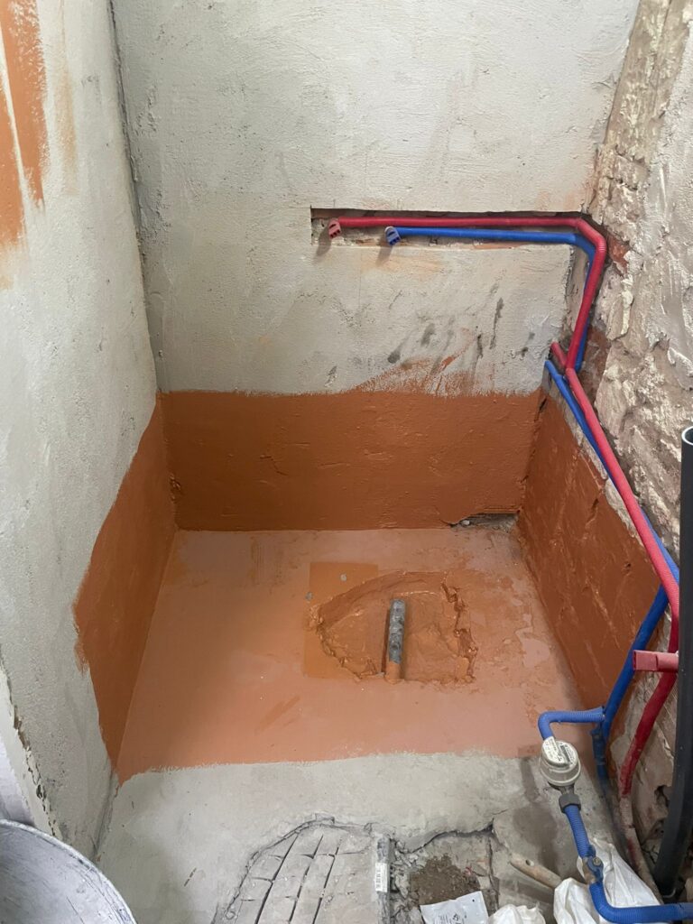 Plato de ducha de obra impermeabilizado con nuevas tuberías de fontanería