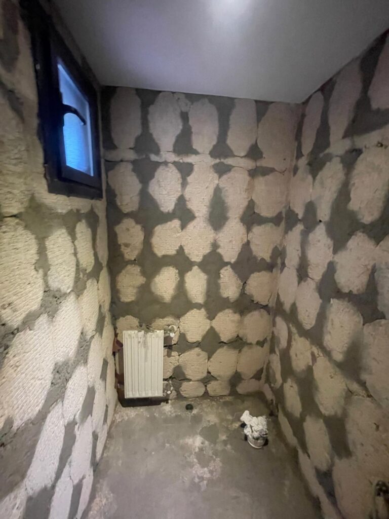 Baño en obra con paredes preparadas con cemento cola para alicatar